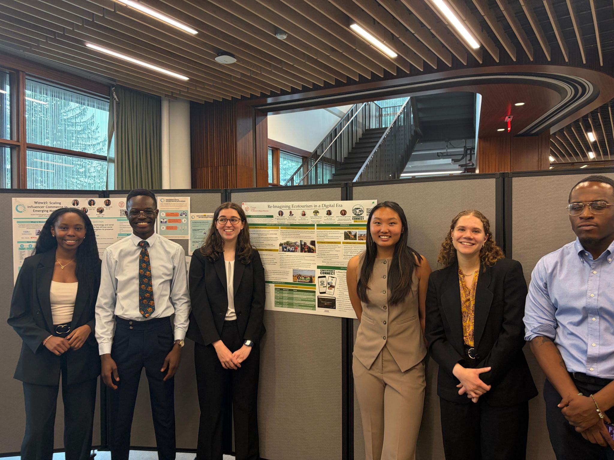 The SMART Fellowship team standing beside their research poster at the final presentation